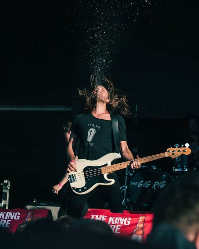  Bass guitarist on stage playing with a strap