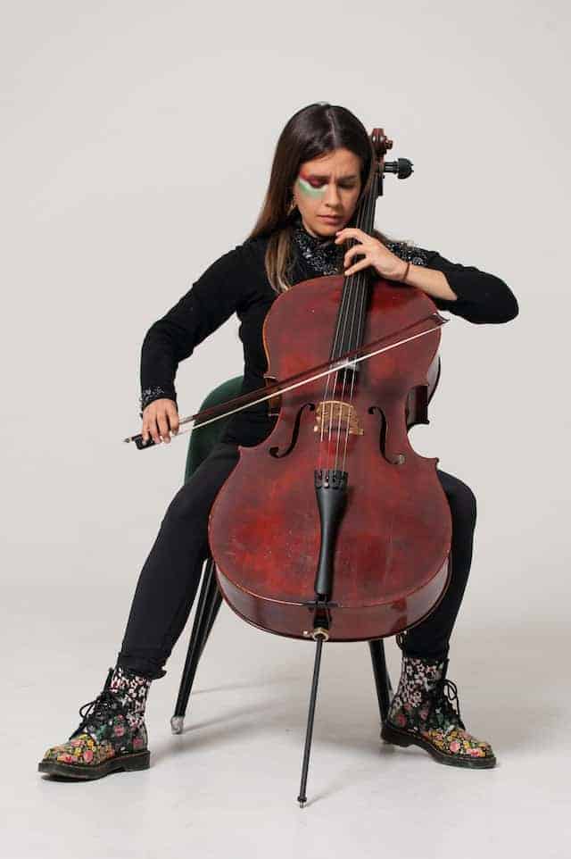 cool woman with face paint playing cello