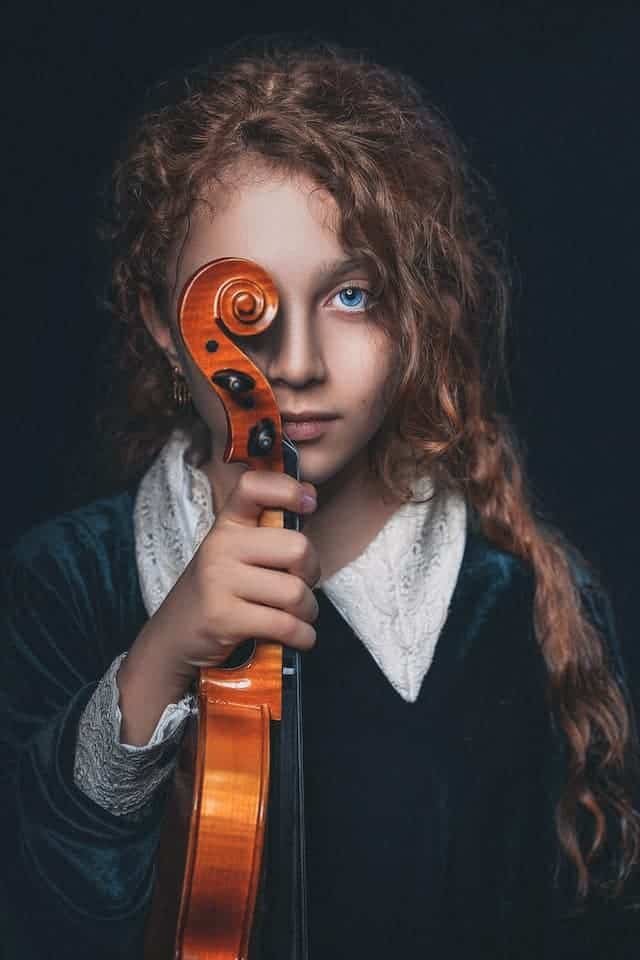 girl holding a violin to her eye
