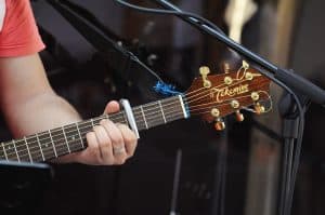Acoustic guitarist using a capo