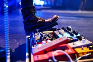 Guitarist stepping on a guitar pedal at a gig