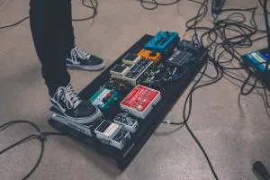 Guitar pedals on a pedal board in a chain on stage