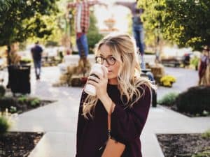 Lady drinking a coffee showing what to avoid to care for your voice