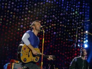 Chris Martin singing on stage with a guitar