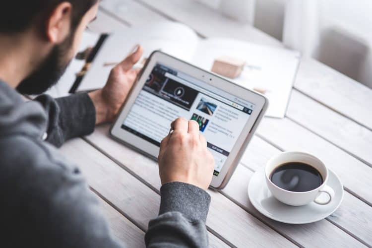 man using tablet to learn to speed read