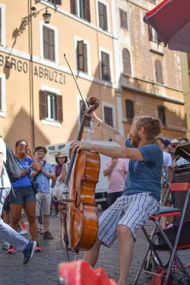 man busking with cello on street