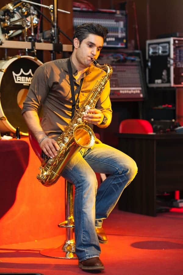 saxophone player sitting on a musicians stool