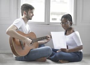 Girl practising singing with a guitarist