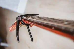 Spring loaded capo being used on the head of an acoustic guitar