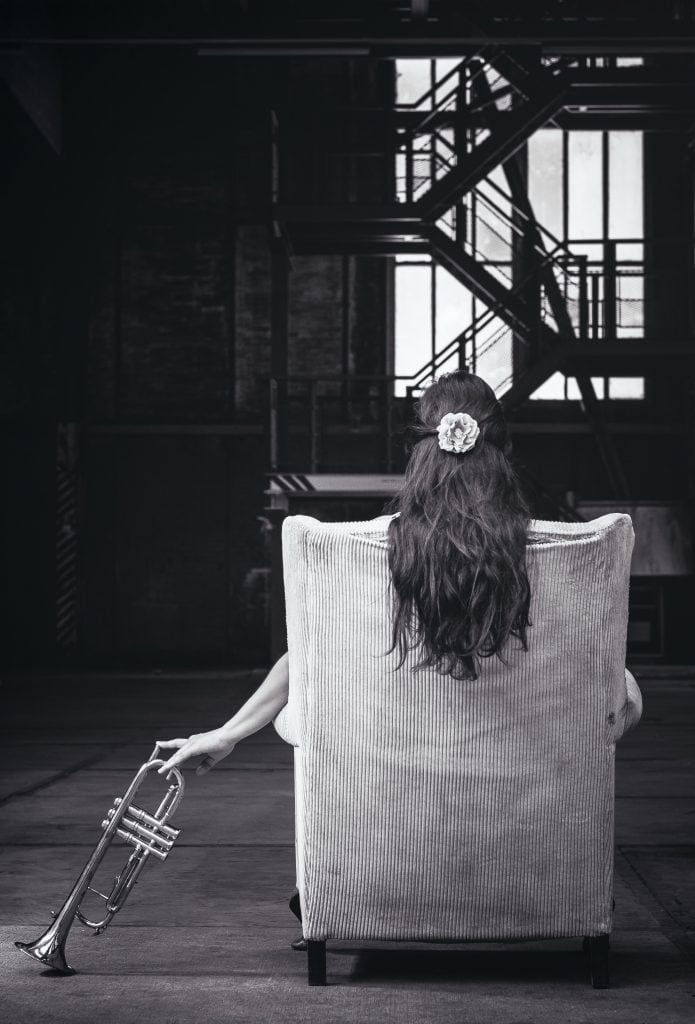 woman in warehouse with trumpet